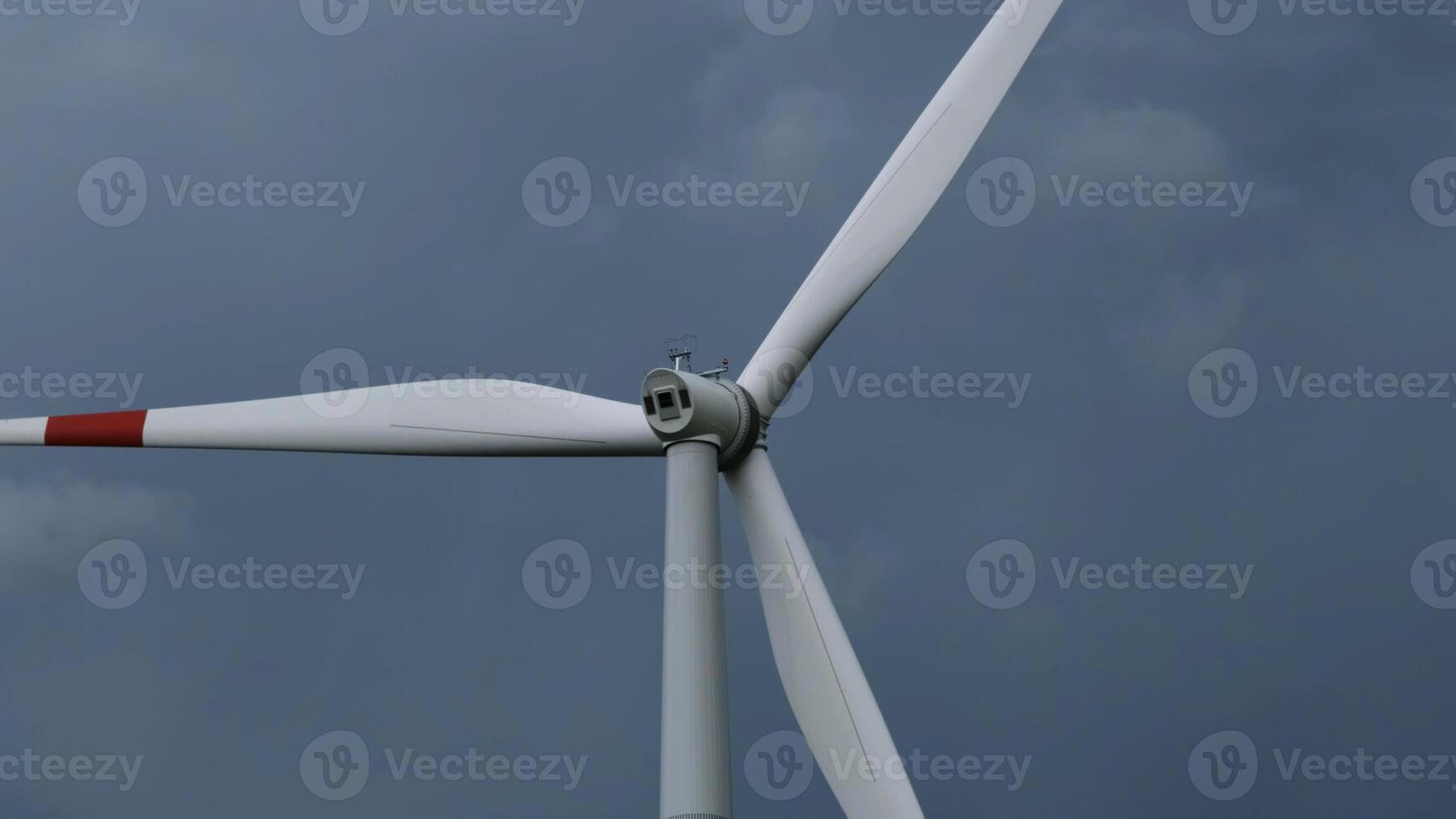 Windmill or wind turbine on wind farm in rotation photo