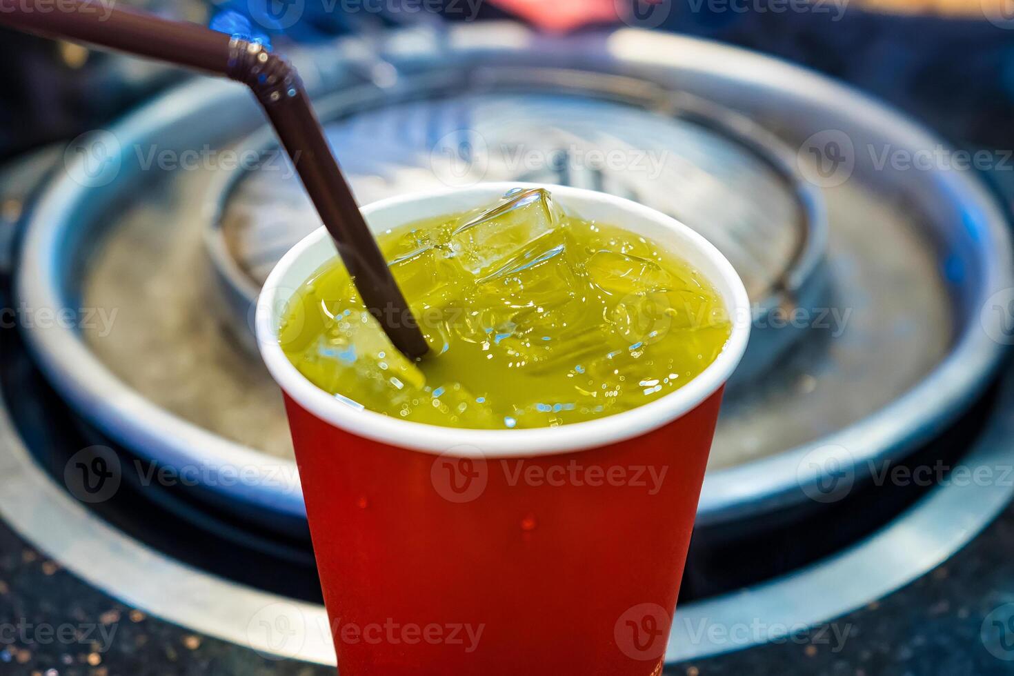 Cool and Refreshing Iced Green Tea in a Red Cup with Ice Cubes photo