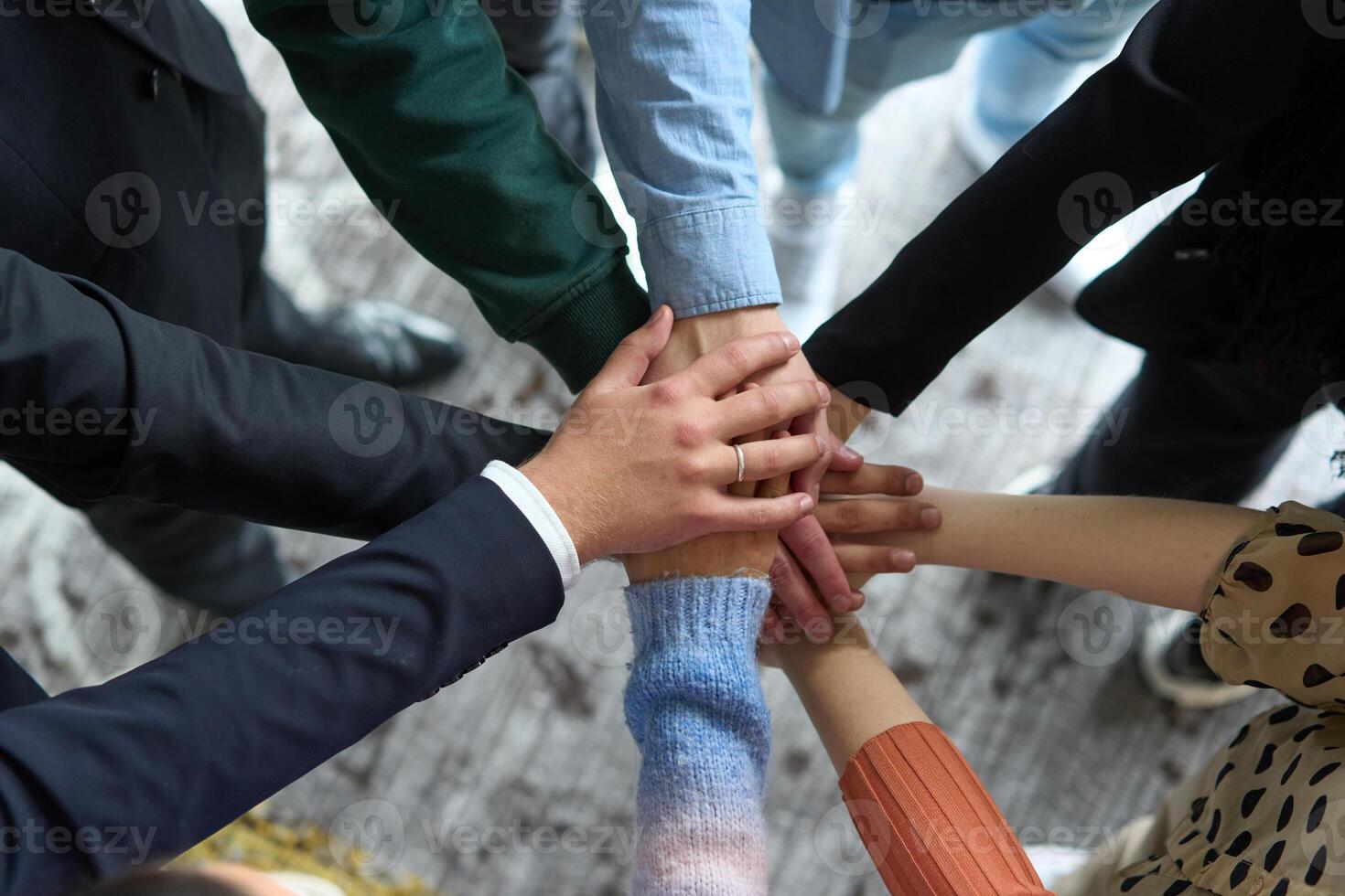 A top view of business people joining hands in a circle, symbolizing unity, collaboration, and shared success in the workplace photo