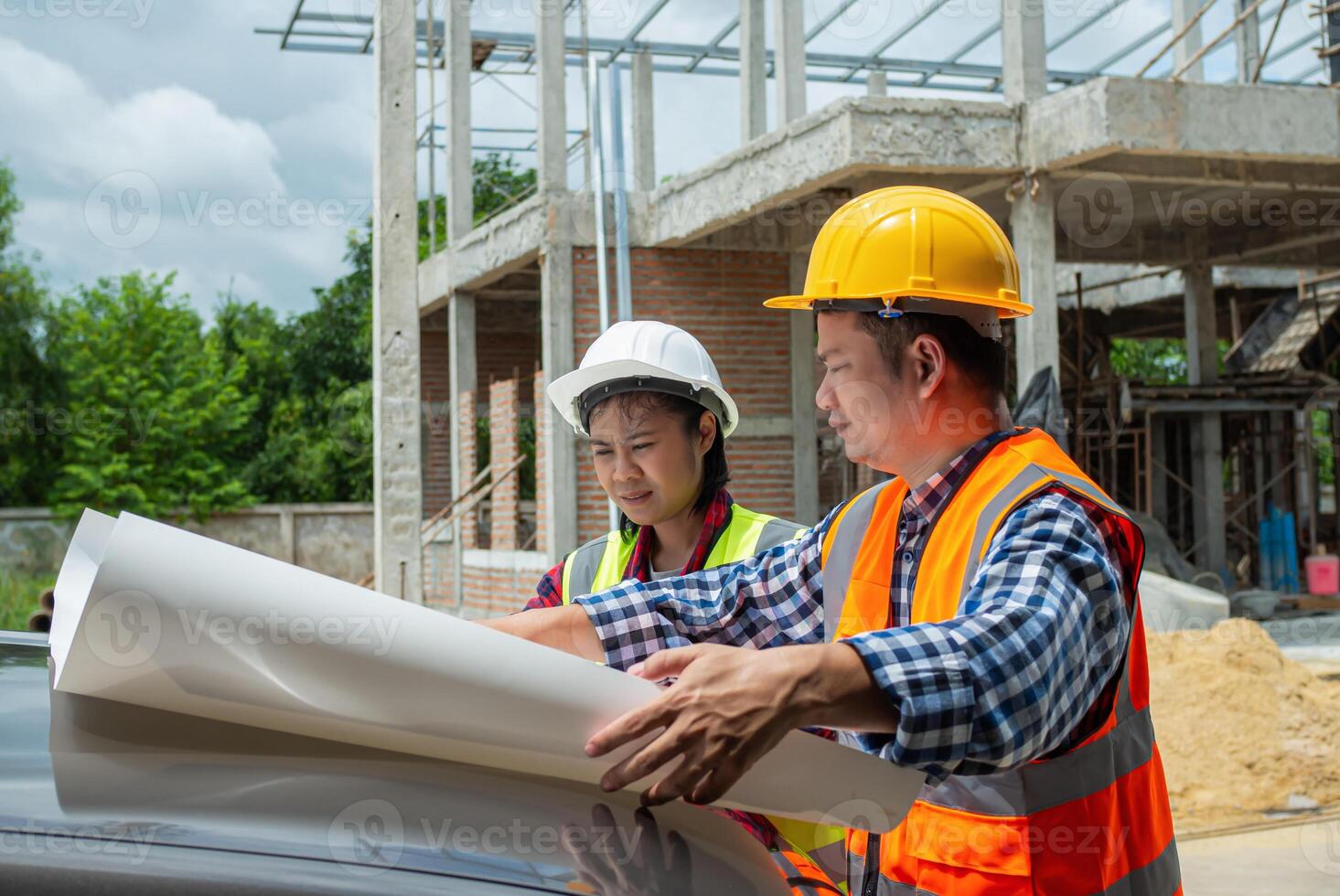 Engineering and architecture concept, Team engineers checking blueprint and planning project working outdoors building side on a worksite, Engineers having meeting regarding new construction phase. photo