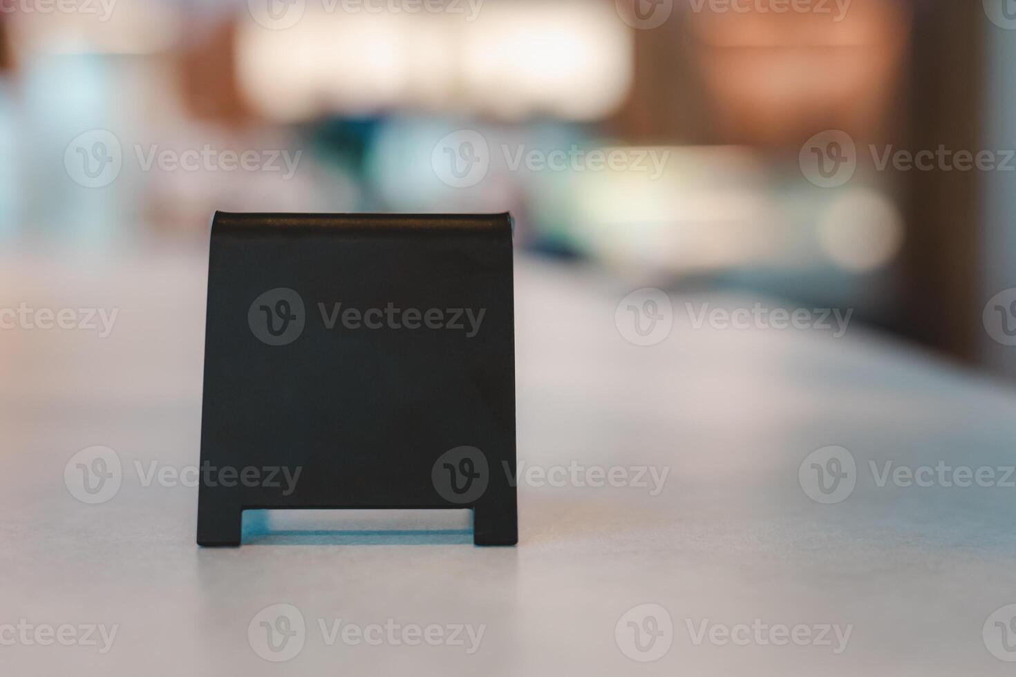 A blank black sign is placed on a cement table for Enter the text of your restaurant, store, or cafe. photo