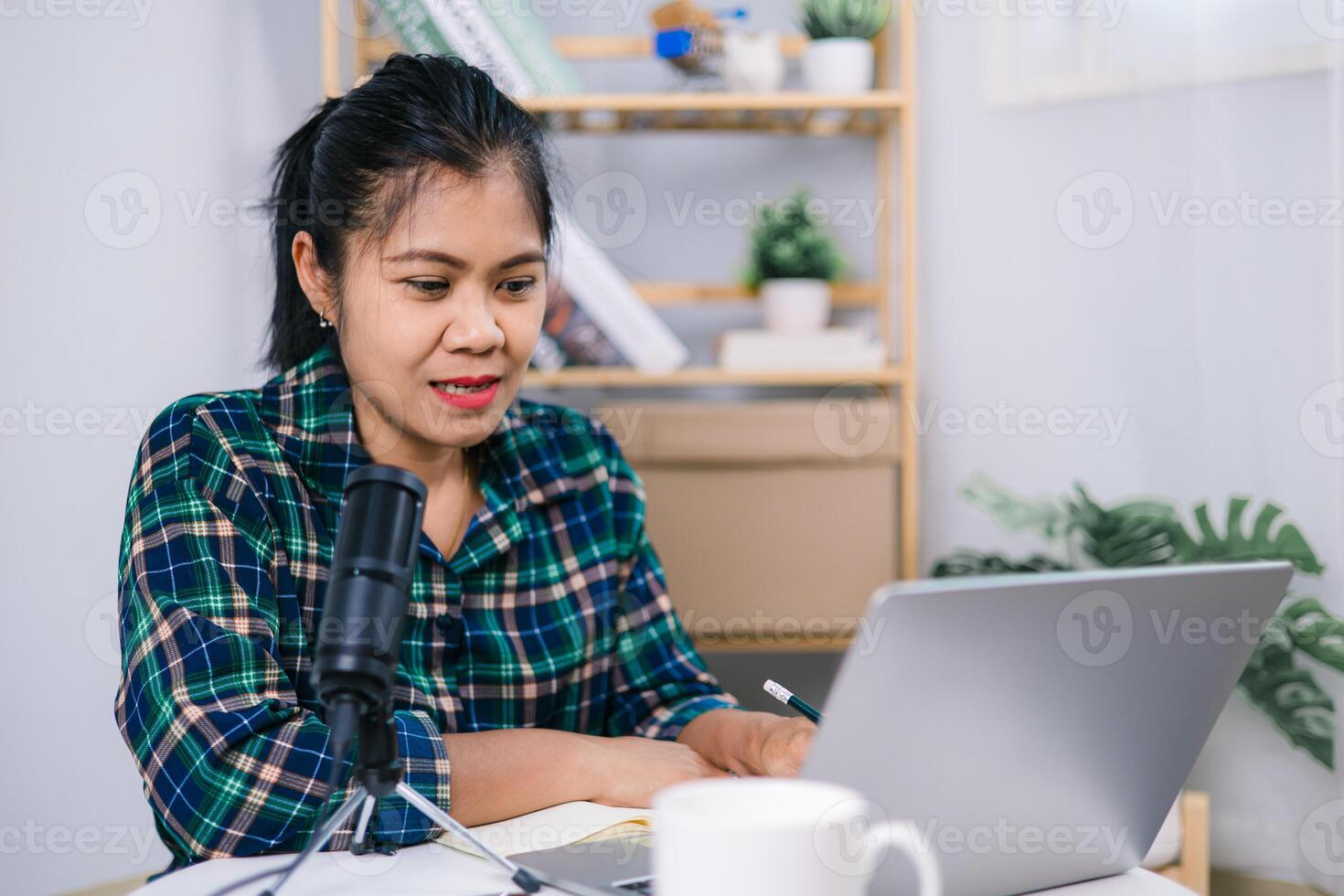 Online live streaming at home, Woman wearing headphones sitting at a desk speaking into microphone and recording a podcast, Record podcast interview for radio, Content creator concept. photo