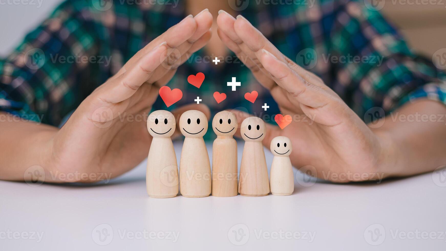 Human hands are choosing life insurance and investing to reduce risk, Wooden dolls with a plus sign and red heart represents protection, Health care planning, Concept of insurance and protection. photo