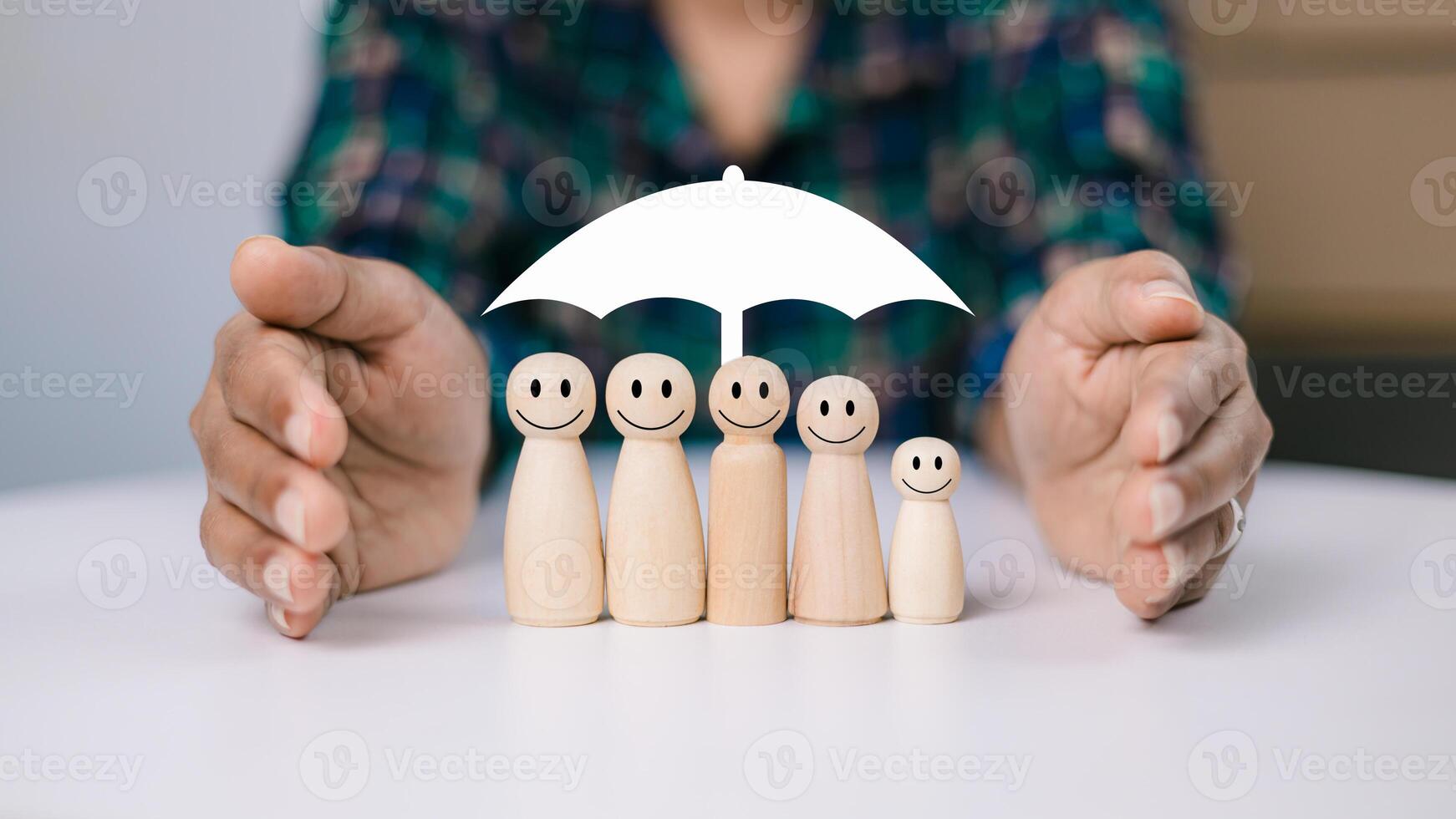 Concept of insurance and protection, insurance planning, Healthcare and finance. Hand and white umbrella give protection to wooden dolls representing family safety protection. photo