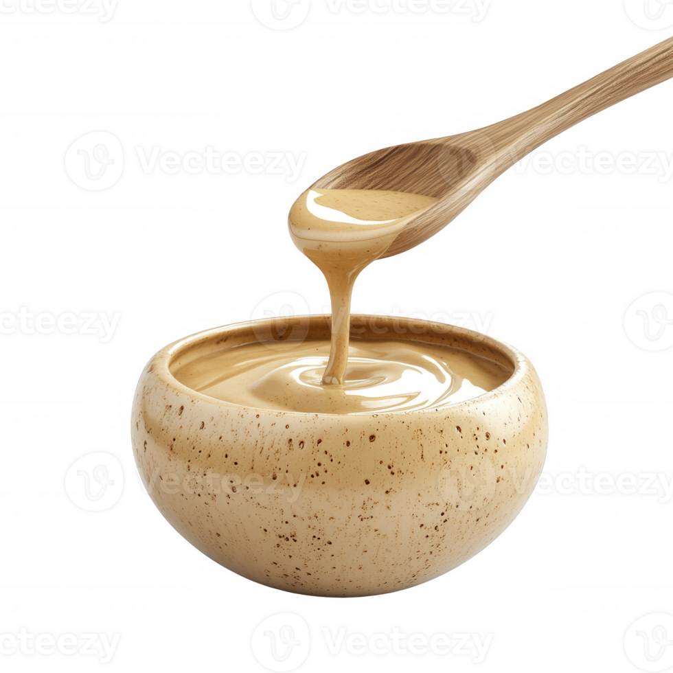 Creamy tahini drizzling from a wooden spoon into a rustic bowl, perfect for dishes. png