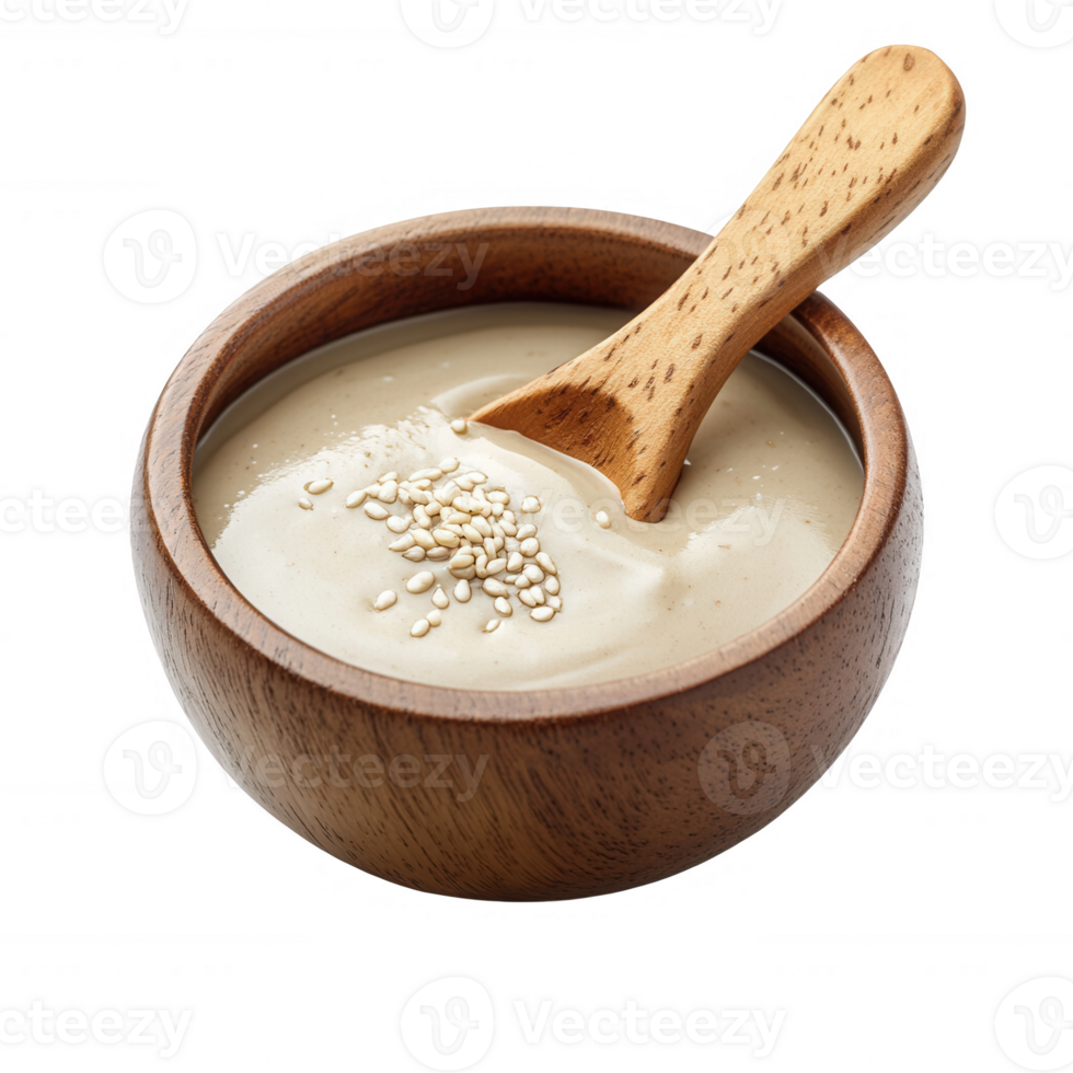 Creamy tahini sauce in a wooden bowl with a wooden spoon, garnished with sesame seeds. png
