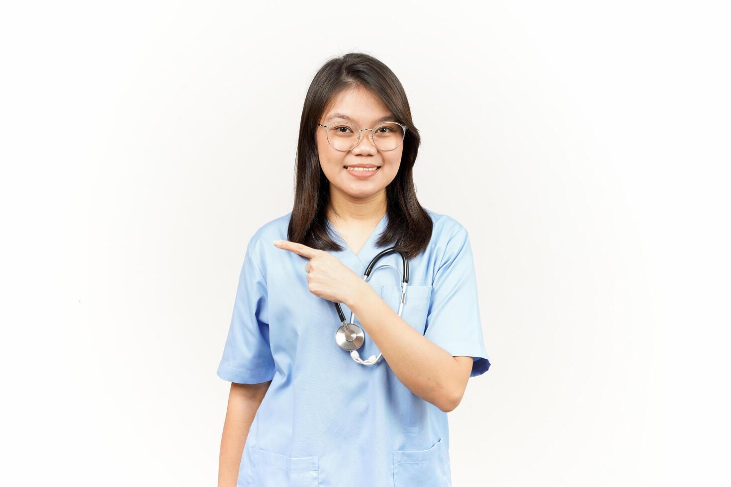 Showing Product and Pointing Side Of Asian Young Doctor Isolated On White Background photo