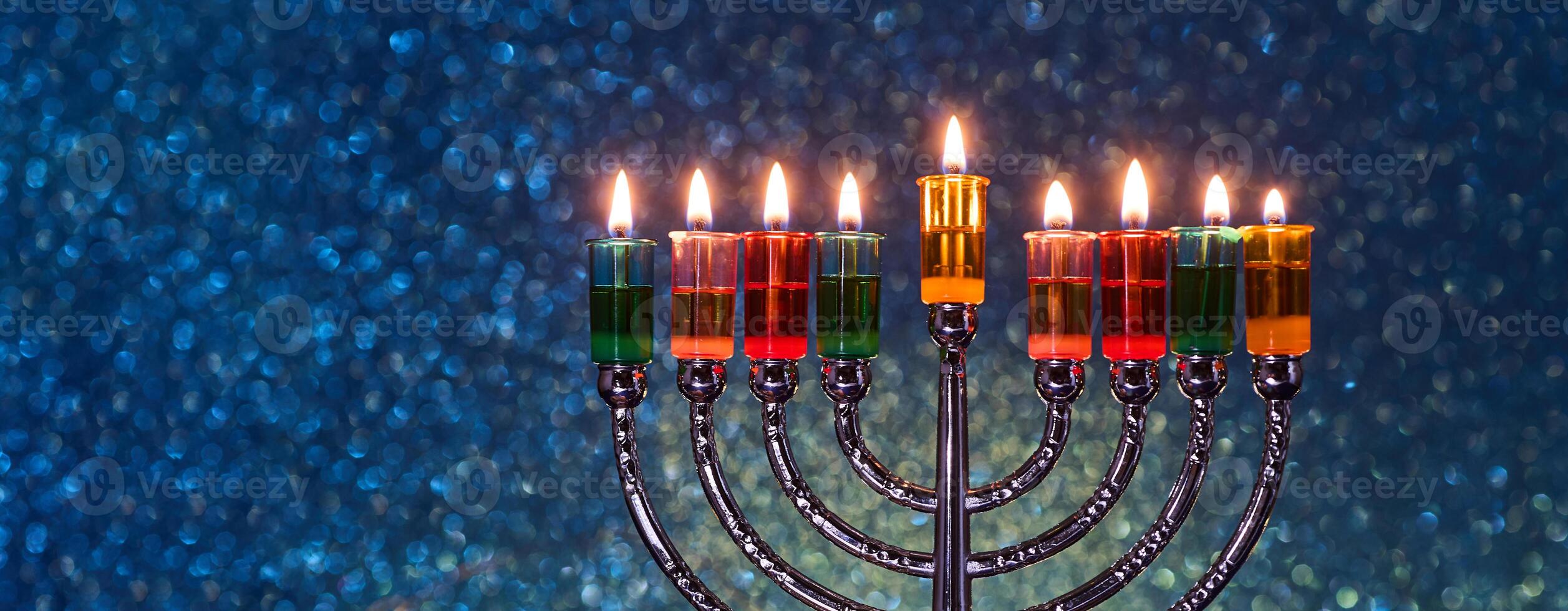 Hanukkah Menorah with burning candles on dark background with bokeh lights. photo