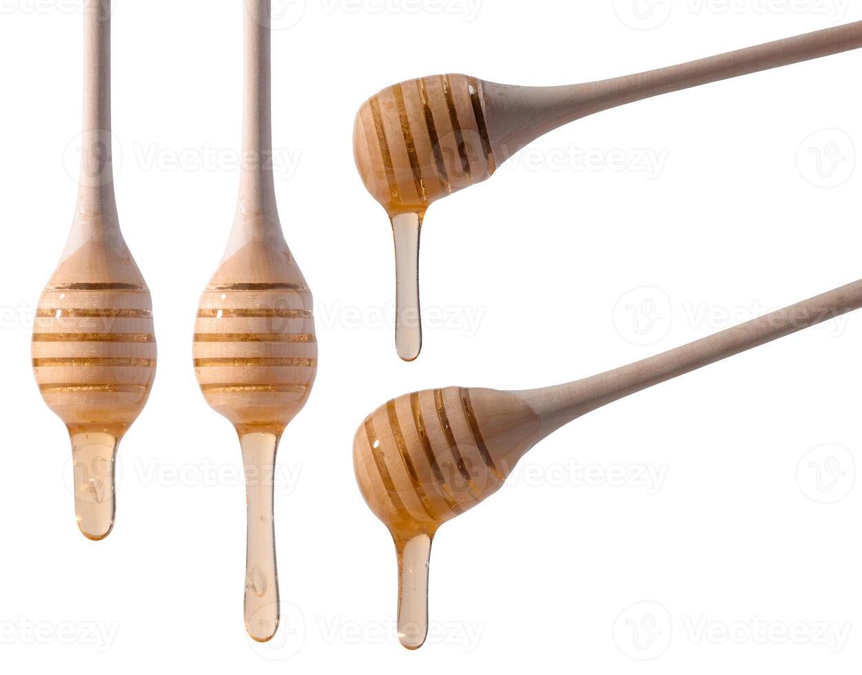 Flowing drops of yellow honey from a wooden stick on a white isolated background photo