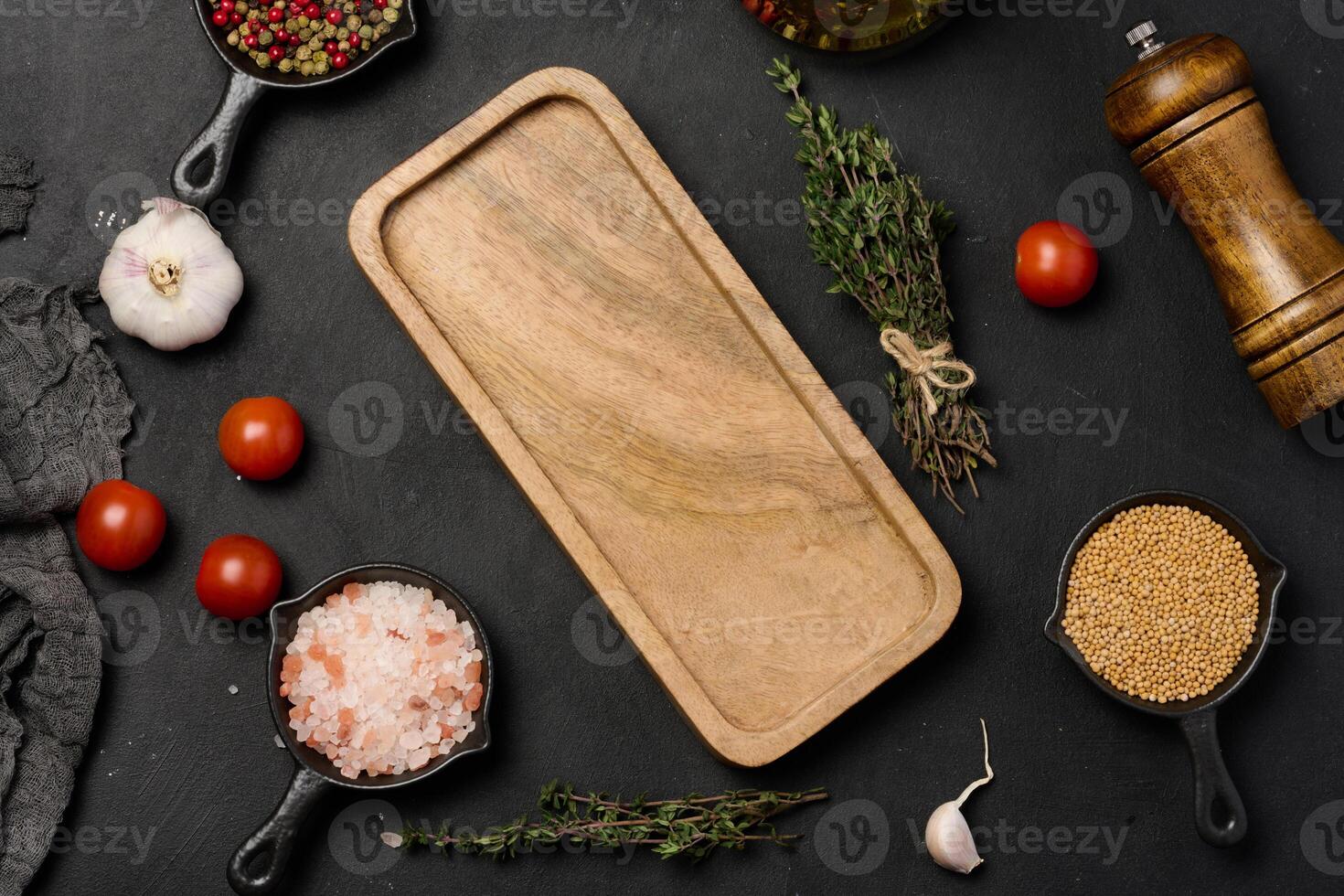 Wooden board and spices on black background, salt and mustard, thyme. Top view photo