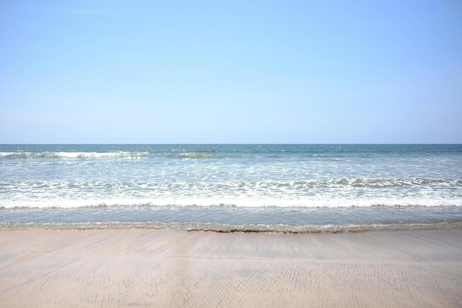 landscape of horizontal calm blue sea with wave on the beach with cloud and blue sky in bright day. Travel destination summer of ocean in Bali, Indonesia photo