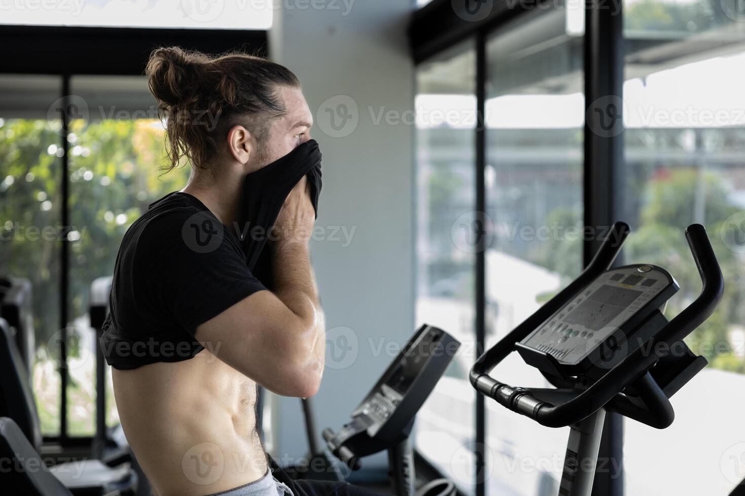 Portrait of caucasian muscular sport man with perfect abs and bicep muscle inside the gym with dark background for cardio exercising and workout in high contrast low key lighting studio photo