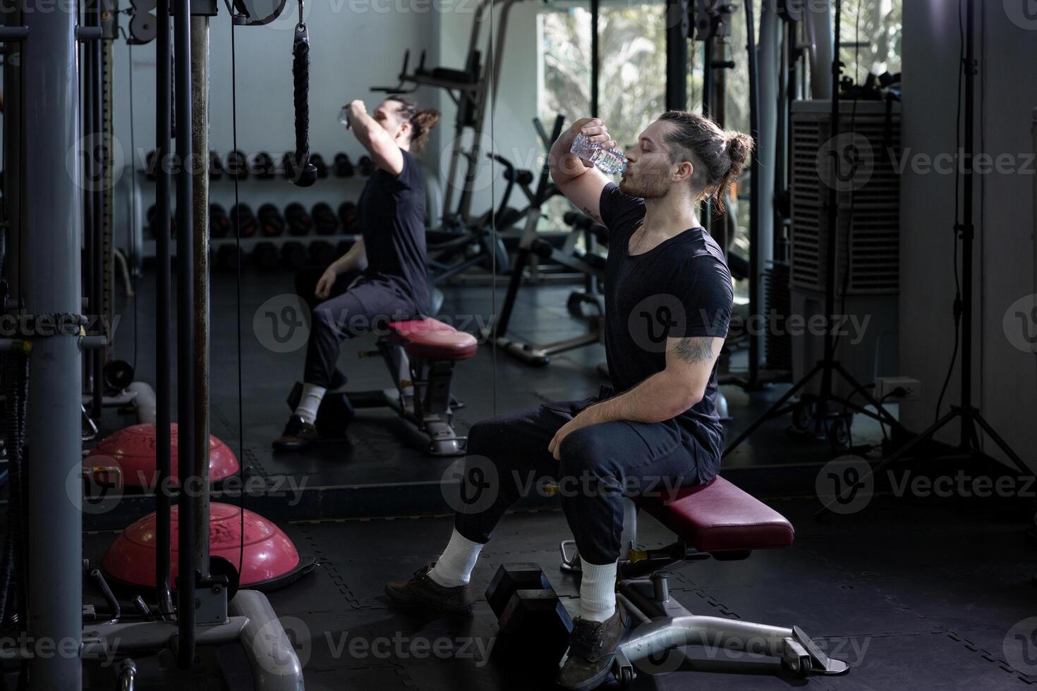Caucasian man enjoy morning exercise in the gym while having a break to drink mineral water for refreshment and rehydration concept photo