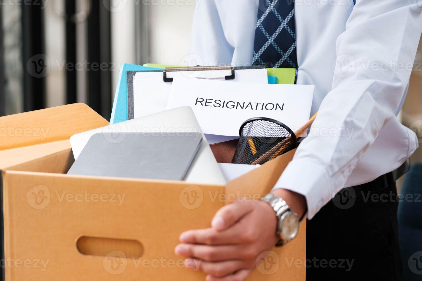 Employee packing belongings into a box during a job change or resignation photo