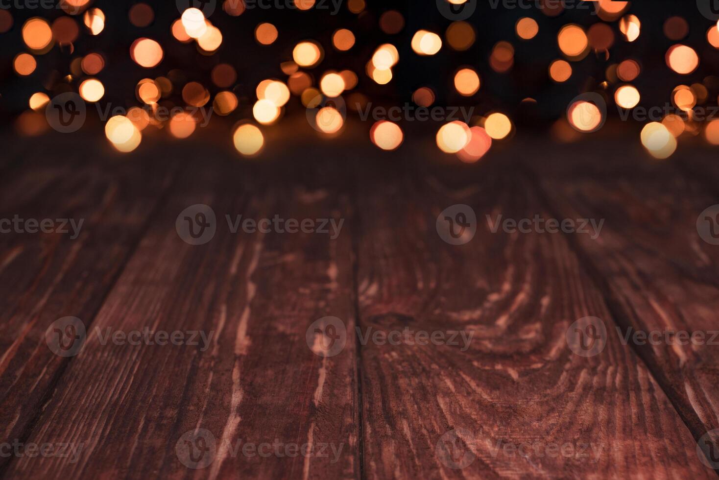 Empty rustic wooden table with blurred Christmas lights at background. photo