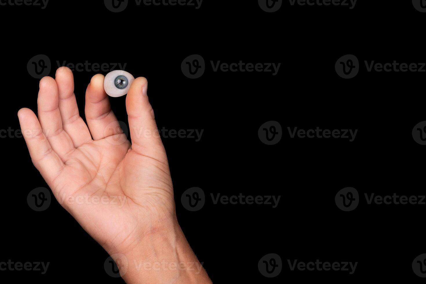 Cosmetic prosthesis of the human eye on a black background. Selective focus. photo