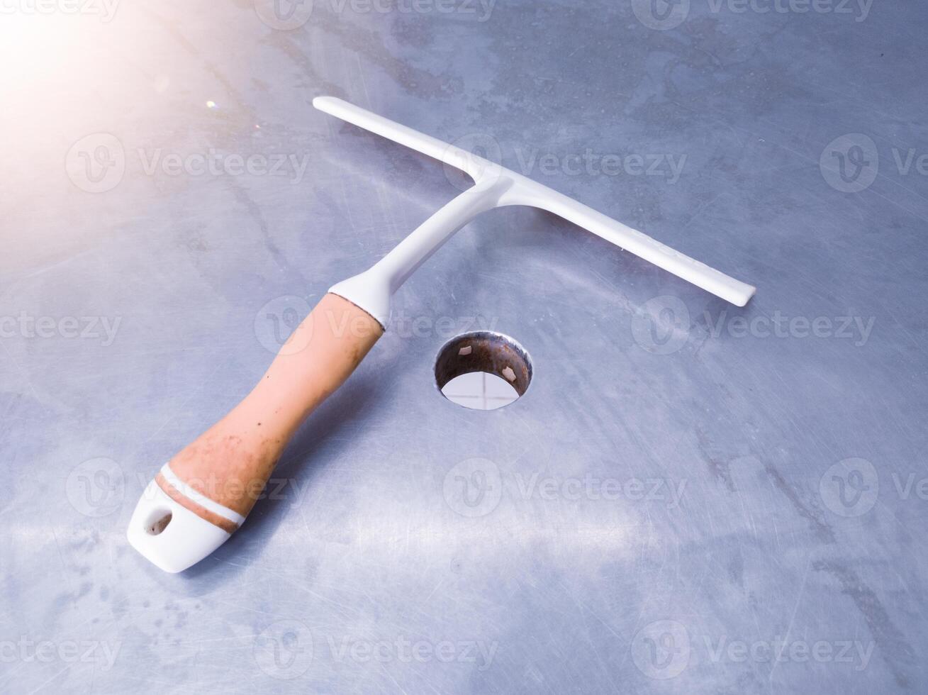 A rubber squeegee is used to clean stainlees boards. photo