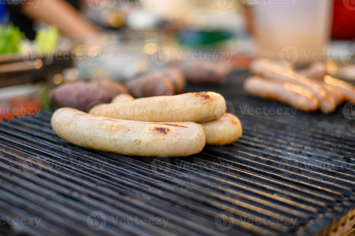 Pile of white pork sausage grilling on stove photo