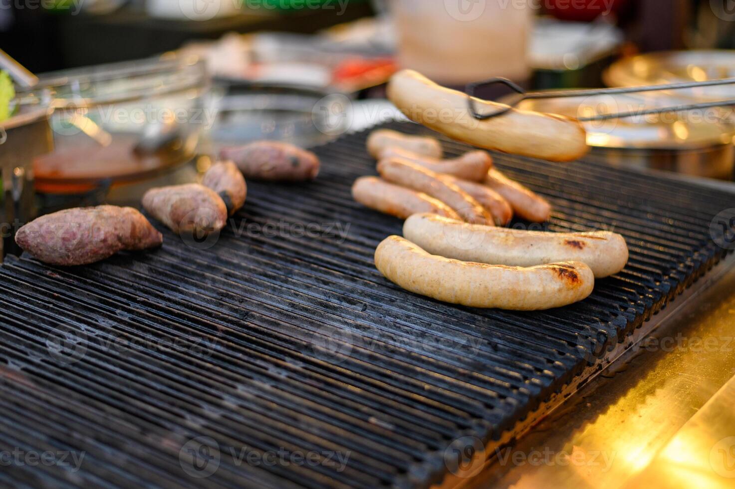 Pile of white pork sausage grilling on stove photo