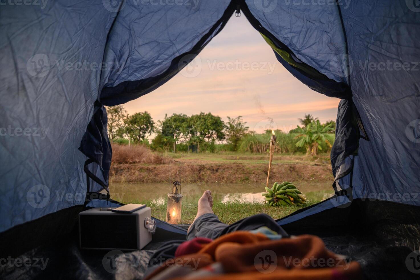 View from inside of tent with relaxing and campfire near swamp photo