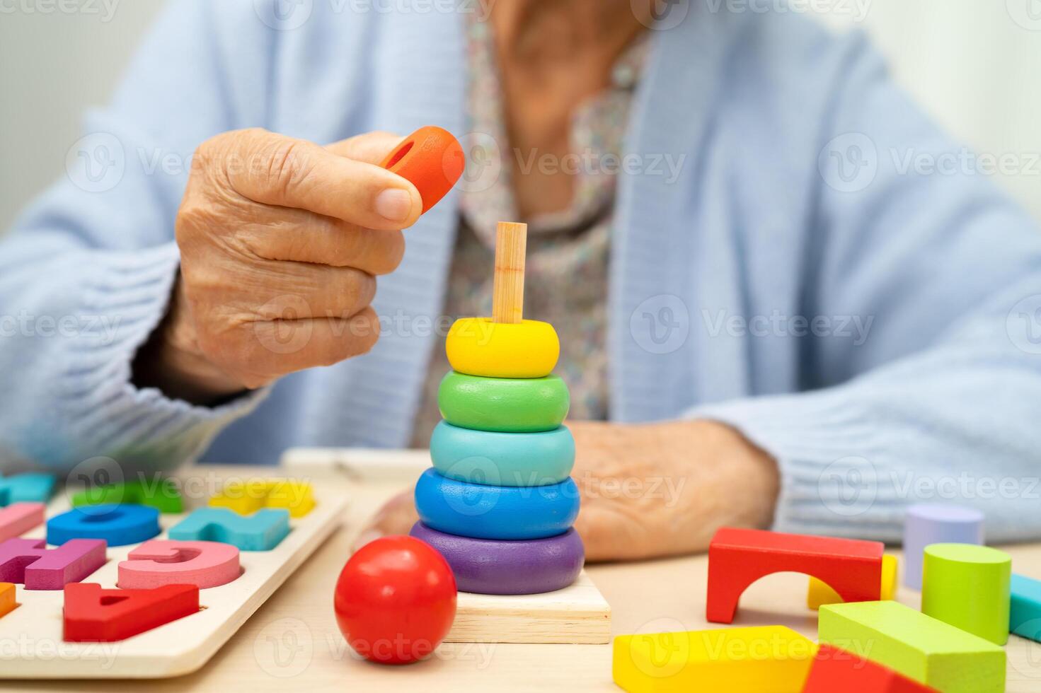 Alzheimer disease AD, Asian elderly woman patient suffering from dementia learn practical motor skills rehabilitation. photo