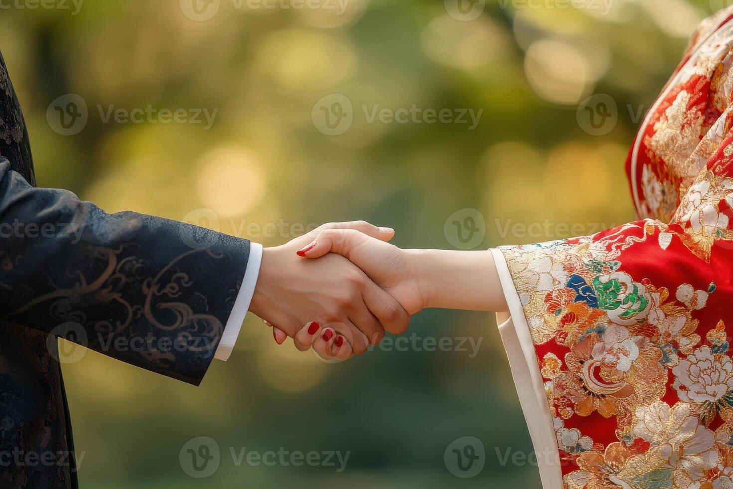 Asian businessman and businesswoman shake hands in formal setting photo