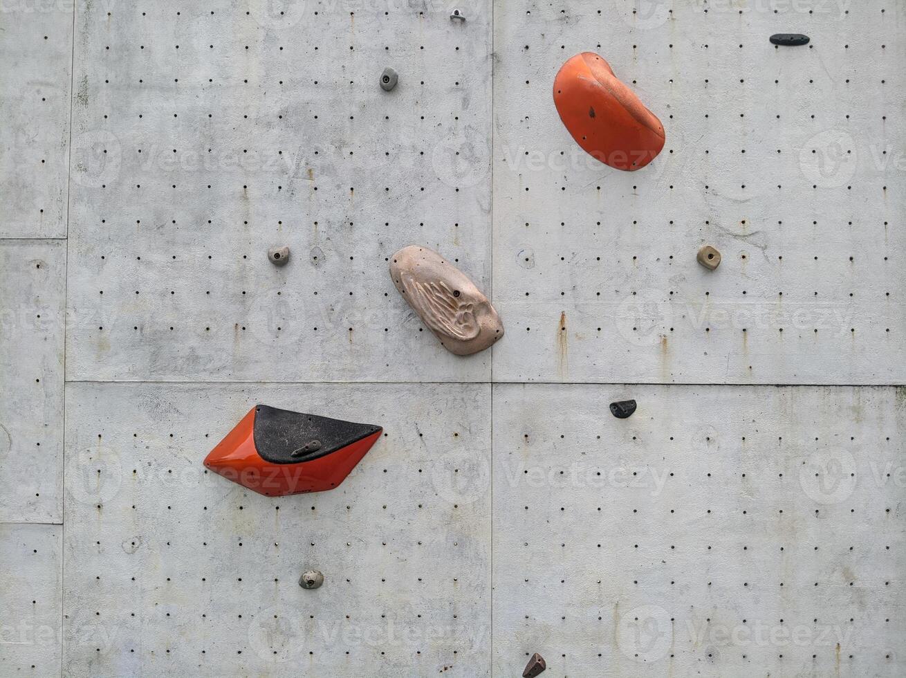 a climbing wall with orange and black objects photo