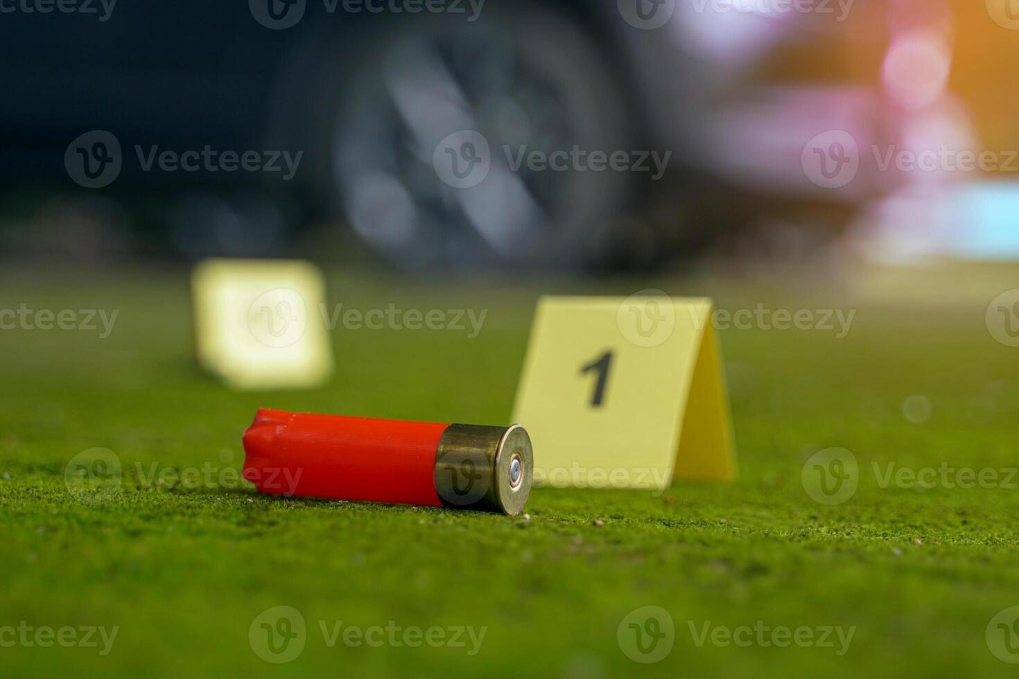 Bullet casings fell on the moss growing on the cement floor and blurry background of the evidence number plate at the scene and the car belonging to the culprit. Concept of investigation photo
