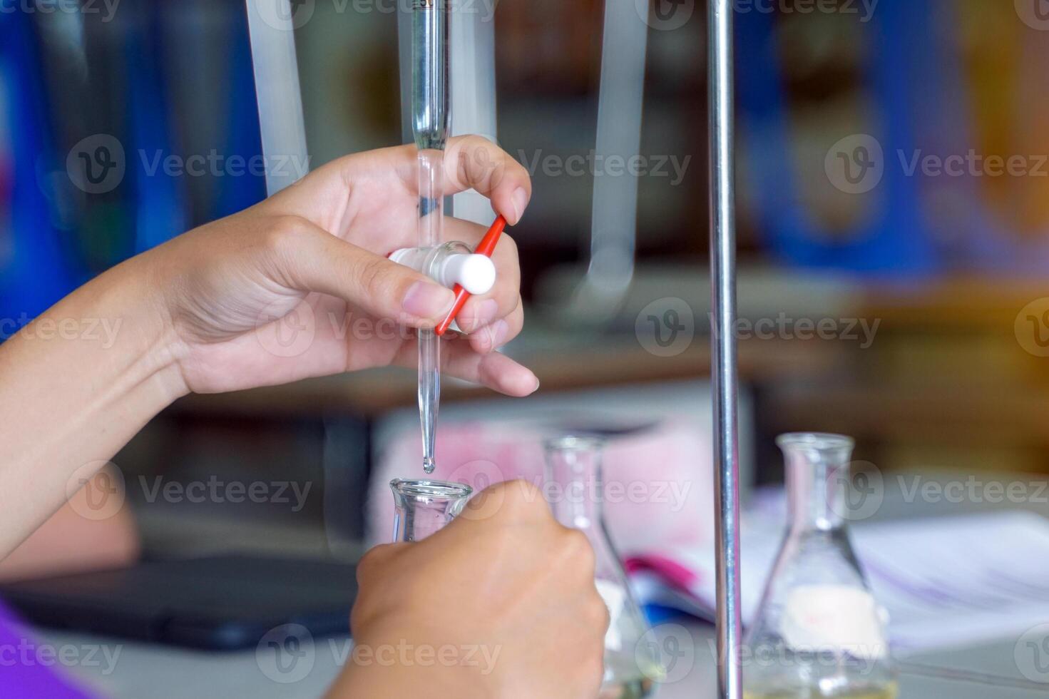 Close-up of a student performing an acid-base titration experiment. Concept of chemistry lab, science, experiment, skills, learning. photo