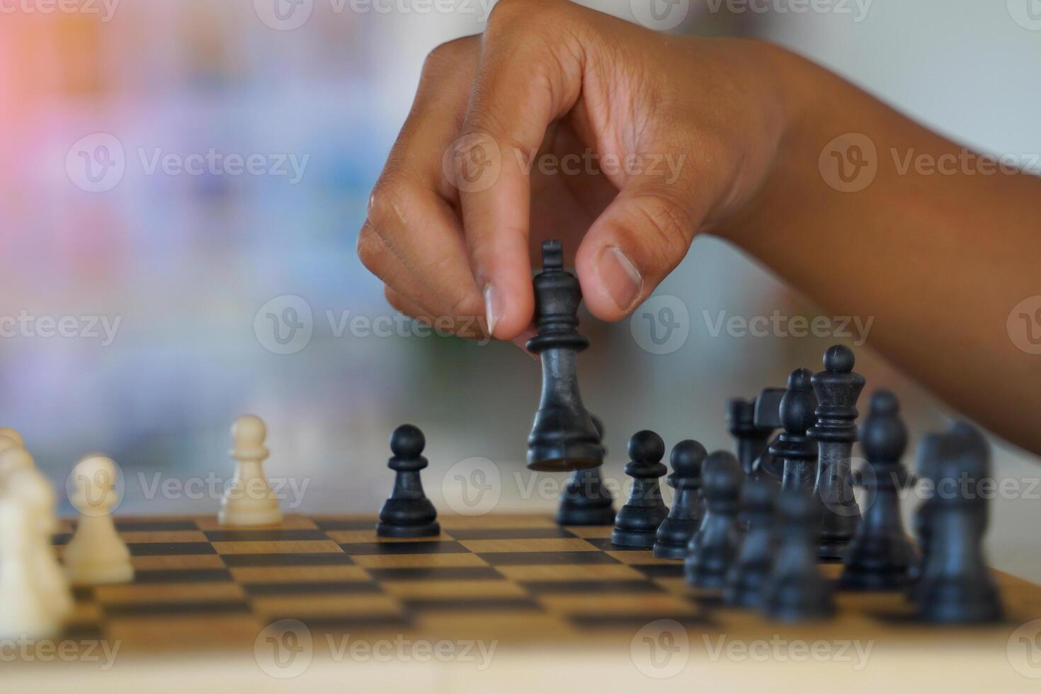 Close-up of a chess player's hand moving pieces on the board as planned to defeat the opponent. Soft and selective focus. photo