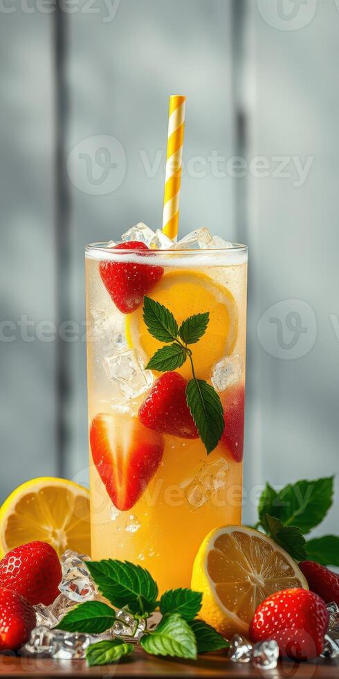 Refreshing summer drink with strawberries and lemons served over ice in a tall glass photo