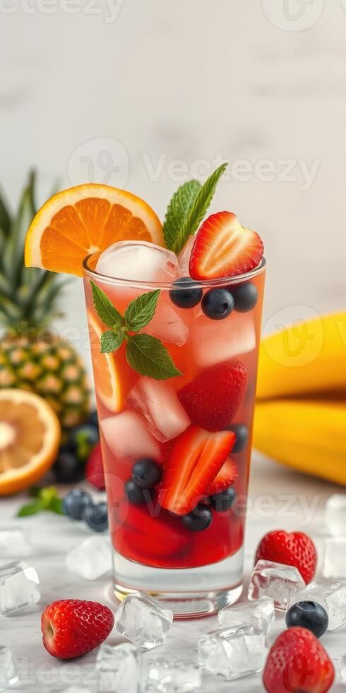 Refreshing fruit cocktail with berries and citrus in a tall glass on a bright table photo
