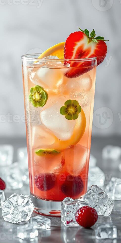 Refreshing fruit cocktail served in a tall glass with ice and colorful garnishes photo
