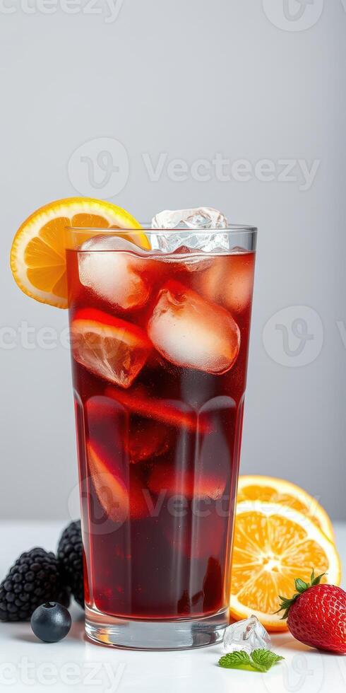 Refreshing iced beverage garnished with citrus and served with berries on a white surface photo