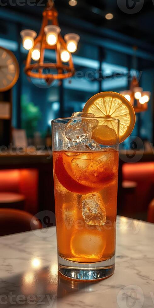 Refreshing iced tea with citrus slices served in a cozy cafe setting during evening hours photo