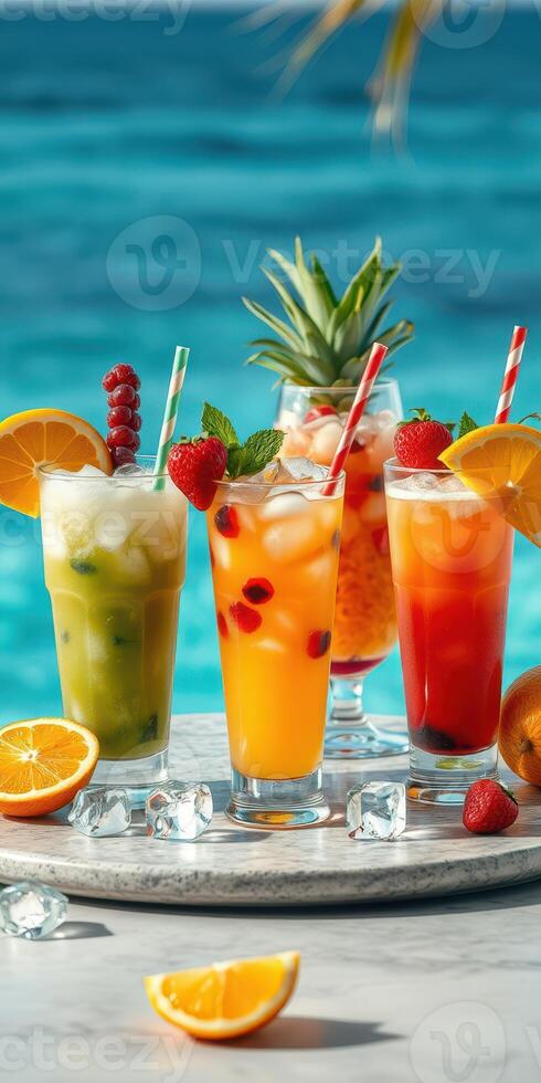 Colorful tropical cocktails displayed on a marble table by the beach with clear turquoise water in the background photo