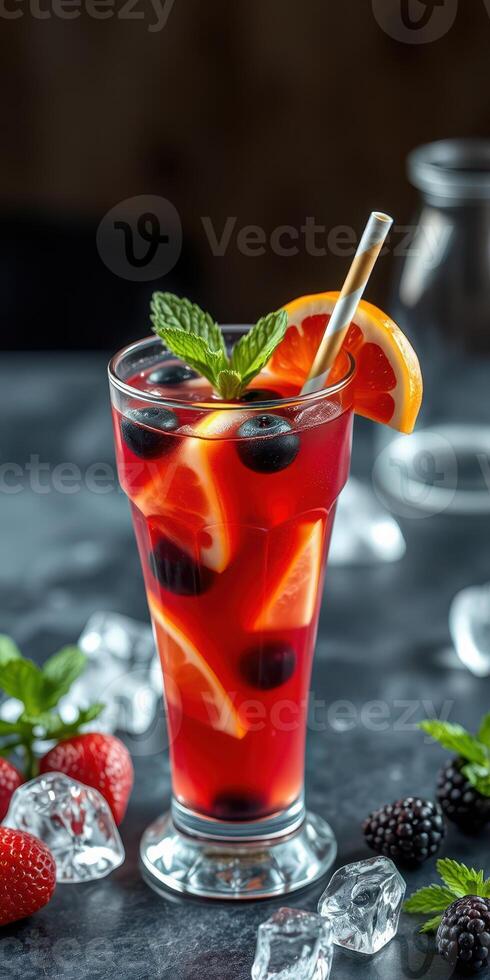 Refreshing fruit cocktail served in a tall glass garnished with berries and mint on a festive table photo