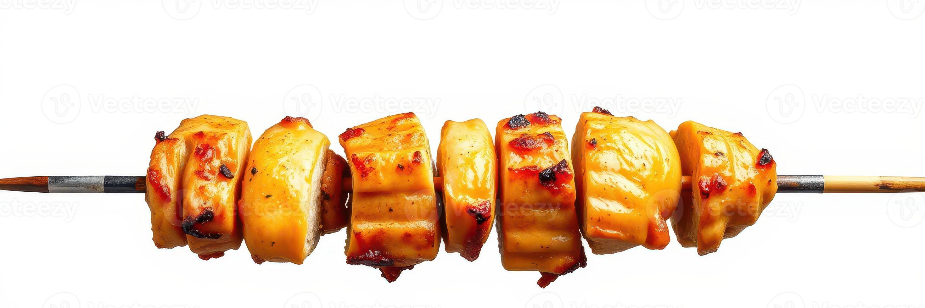 Grilled skewers of marinated chicken arranged on a skewer against a plain background photo