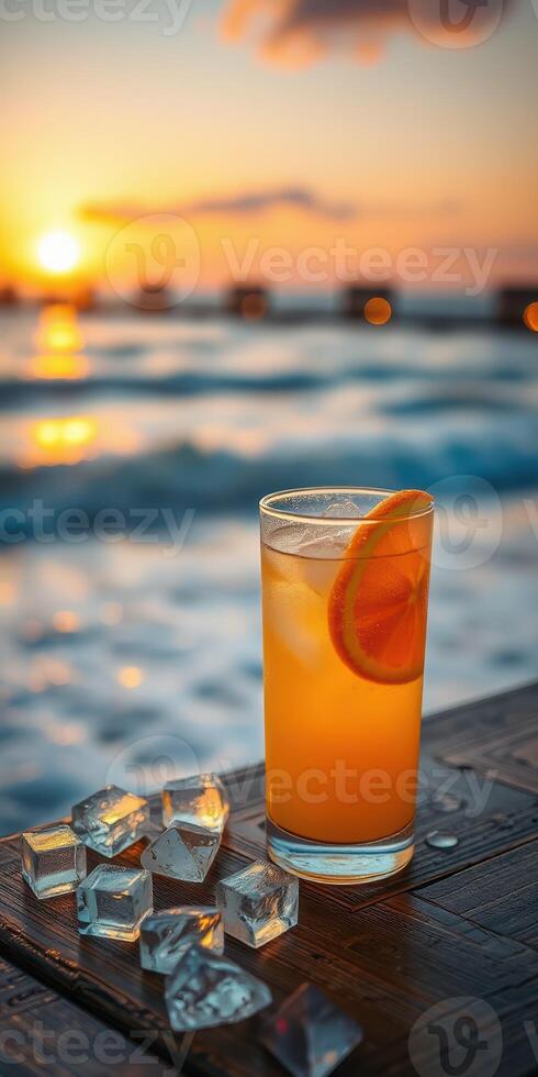 Enjoying a refreshing cocktail by the beach during sunset with waves in the background photo