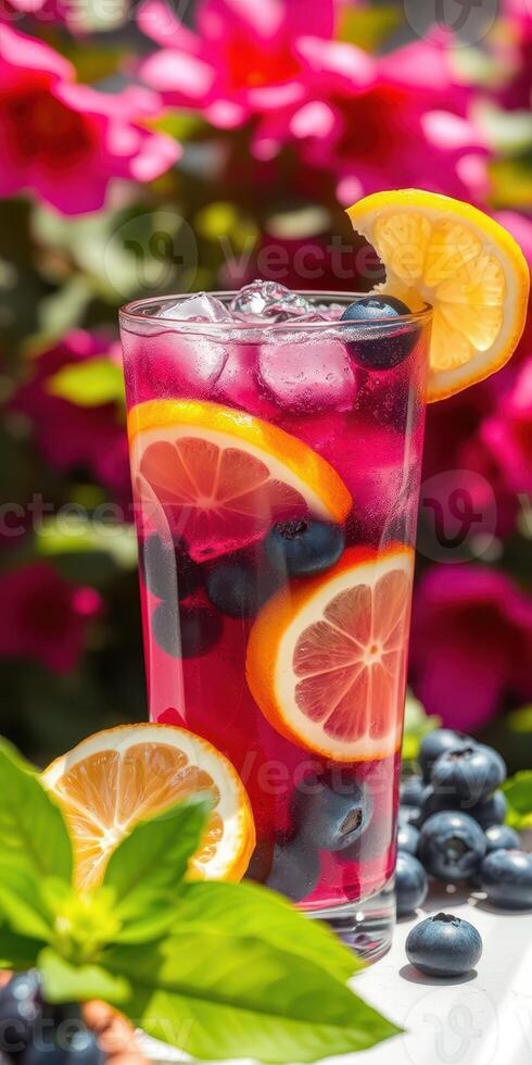 Refreshing summer drink with citrus and berries in a vibrant garden setting photo