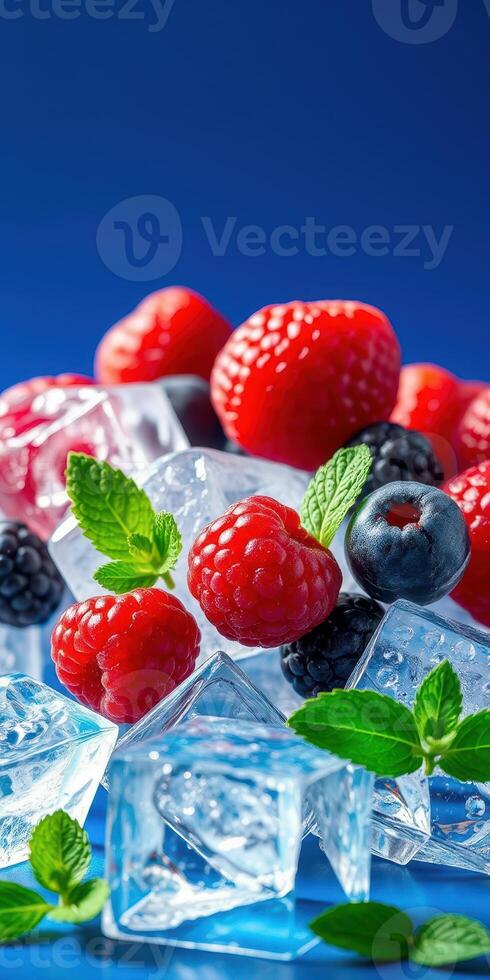 Fresh berries and ice cubes arranged beautifully on a blue background for a vibrant summer treat photo