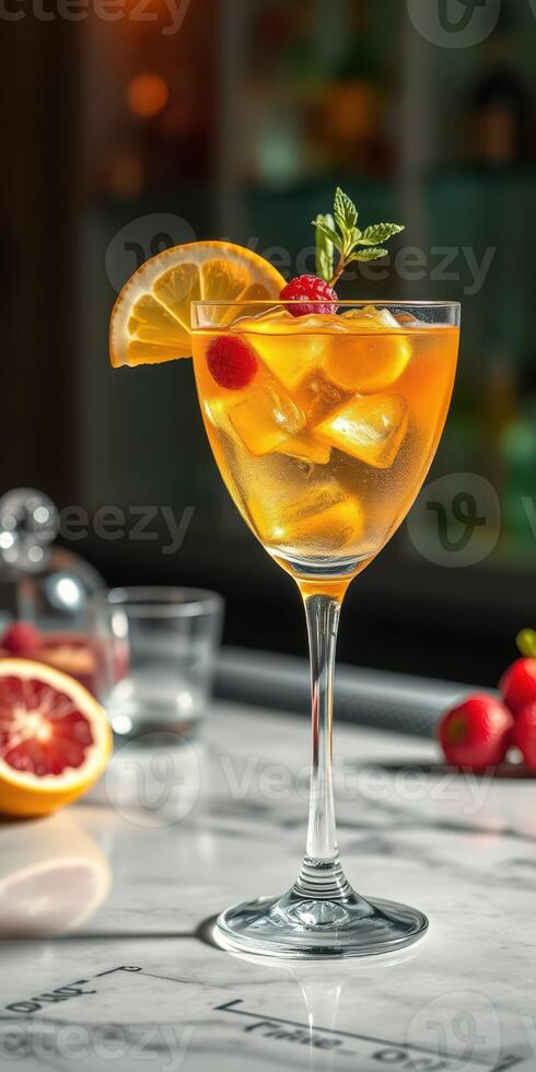 Refreshing citrus cocktail garnished with orange and cherry served on a marble countertop photo