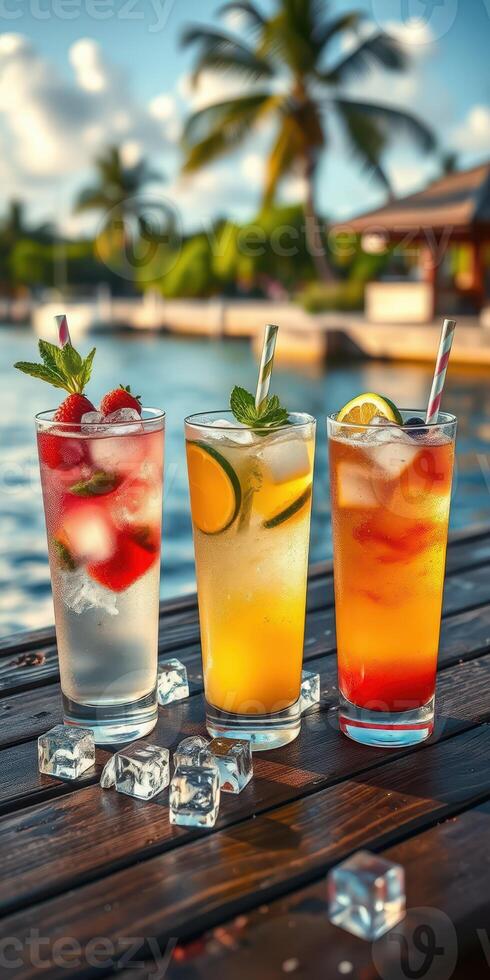 Refreshing tropical cocktails on a wooden table by the water during sunset near a palm tree resort photo