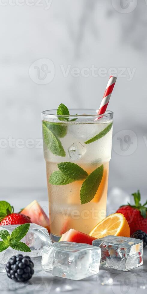 Refreshing summer beverage with mint and assorted fruits served with a striped straw photo