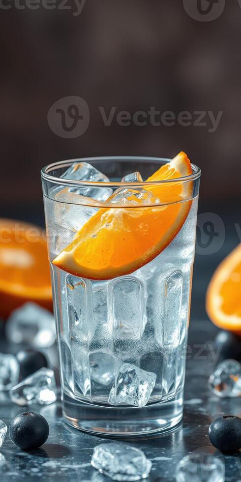 Refreshing cocktail with ice, orange slice, and blueberries on a dark surface in a cozy setting photo