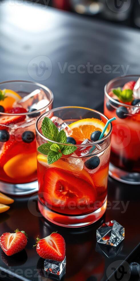 Colorful fruit cocktails with vibrant garnishes served on a black surface during a summer gathering photo