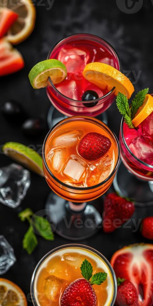 Colorful cocktails garnished with fresh fruits and mint arranged on a dark surface during a summer gathering photo
