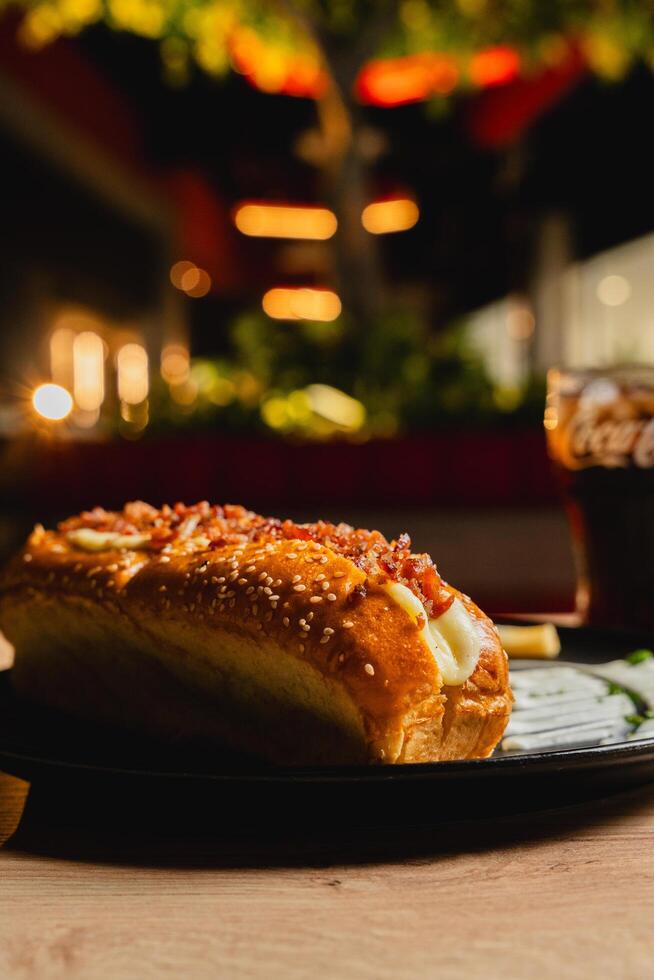a hot dog and a drink are on a table photo