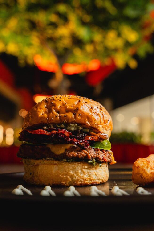 a burger with a bun and a christmas tree in the background. photo