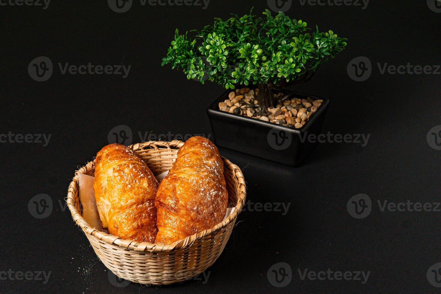 a basket of breads with a plant in the background photo